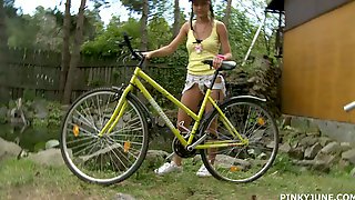Young blonde is riding her bicycle and..
